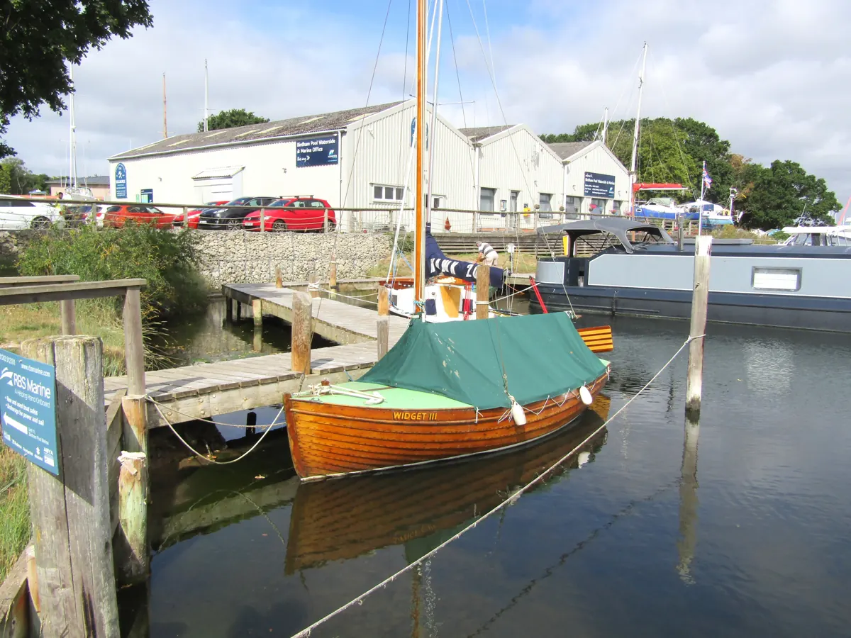 A wooden boat moored in the marina at Birdham Pool