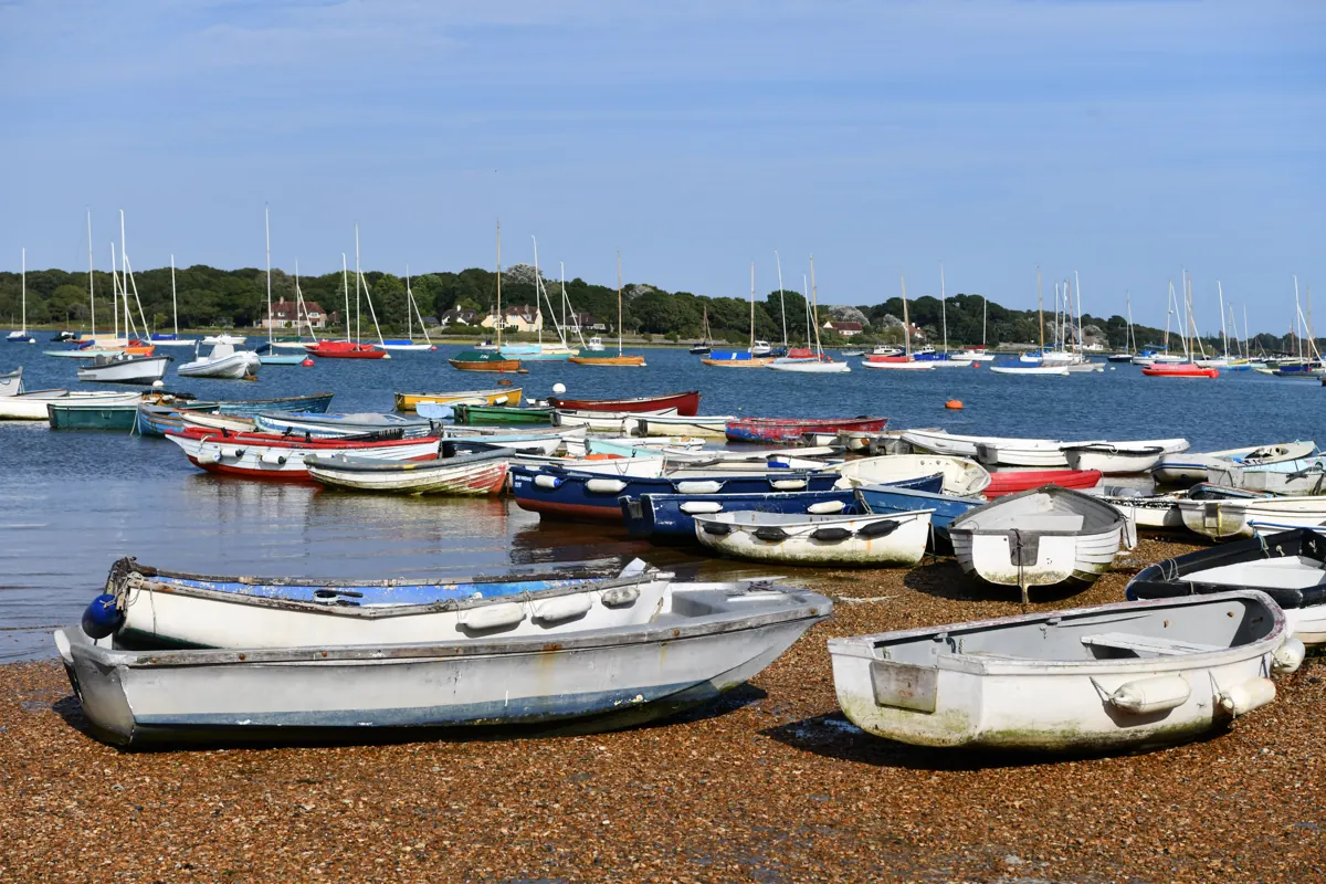 Dinghies drawn up on the shore at West Itchenor, with Chichester Harbour behind