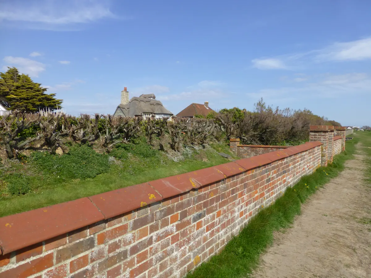 A thatched house behind a sea wall on the West Wittering seafront